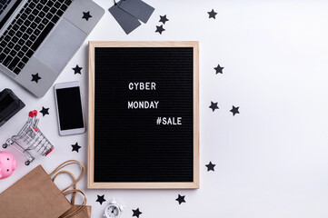 Text cyber monday sale on black letter board with laptop, smartphone, price tags on white background top view flat lay