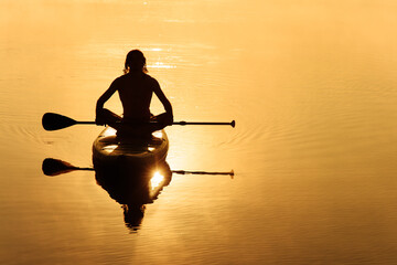 Back view of male paddler swimming on sup board