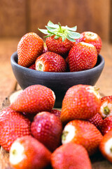 pile of fresh strawberries with spot focus on isolated wooden background