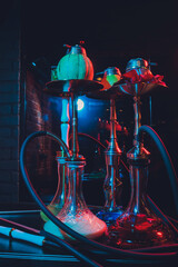 Red shisha hookah with smoke and red sparks on wood table brick, art background. Shisha Concept.