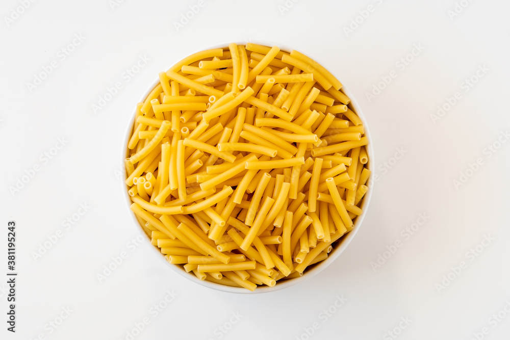 Wall mural raw dry uncooked macaroni pasta spaghetti noodle on white bowl wooden background for basil tomato pe