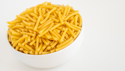 Raw dry uncooked Macaroni pasta spaghetti noodle on white bowl wooden background for basil tomato pesto sauce Homemade Italian food organic whole wheat vegan spaghetti for a healthy meal