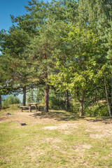 Landscape by the lake in the forest with a wooden table/Lake in the forest with a picnic table. On a sunny day.