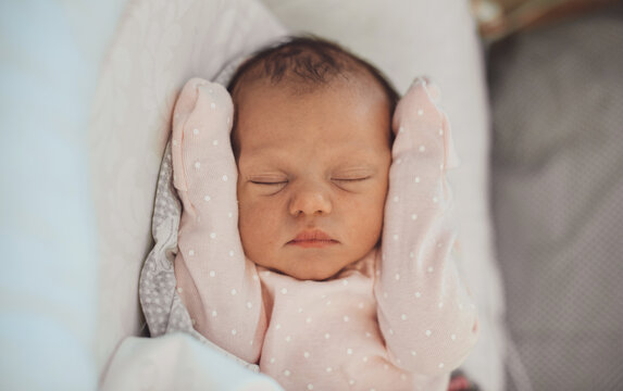 Close up photo of a newborn baby sleeping in white clothes at home