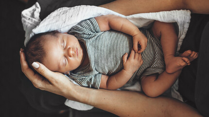 Upper view photo of a newborn baby sleeping on his parents arms - obrazy, fototapety, plakaty