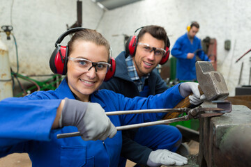 young female blacksmith demonstrating work