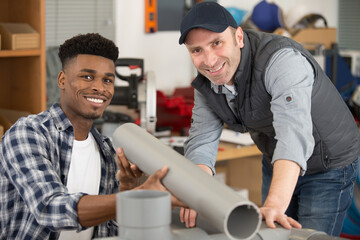 two male workers in plumbing workshop