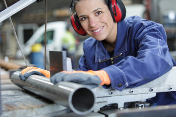 woman cuts pipes in factory