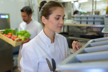 kitchen worker taking cutlery out