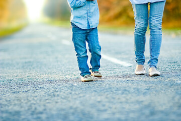 A Happy parent with child are walking along the road in the park on nature travel