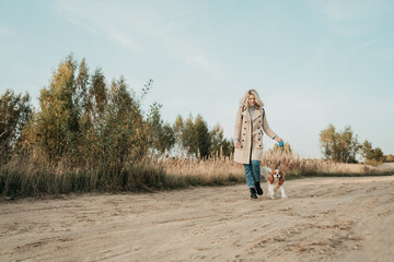 Travel with dog. Young woman walk with her cocker spaniel, backpack on her shoulder