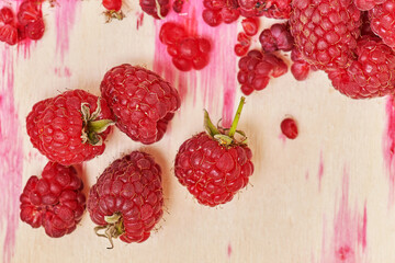 Ripe raspberries on the background of containers with juice stains from berries