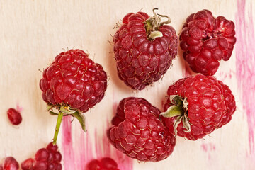 Several berries of red ripe raspberries on a wooden background