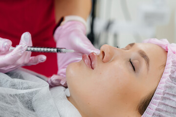 Cosmetology procedure for lip augmentation and wrinkle removal for a young beautiful girl. Cosmetology