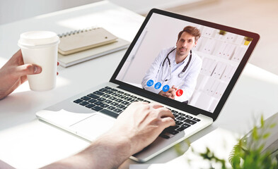 Man with coffee having video chat with doctors