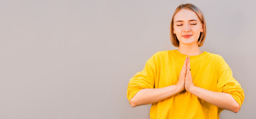 Namaste peace your house. Relaxed peaceful charming friendly european girl press palms together buddhism gesture smiling cute thanking dear guest hold hands pray standing gray background