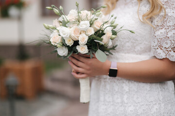 Female hold bouquet of white roses in hands. Mini wedding. Blond hair bride with bouquet of flowers