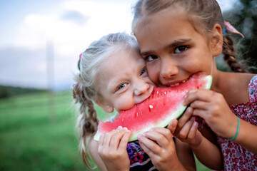 Healthy summer food. Group of kids eating watermelon together in the backyard of farmhouse