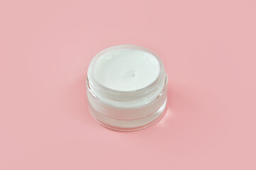Face cream close - up on a pink background. Body care. Cosmetology. 