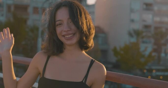 Attractive young woman is wave. Hand gestures, saying hi or bye. Youthful and friendly happy lady.