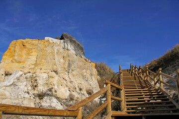 Ascending rustic wooden steps by the Asperillo cliff, natural monument in Castilla beach (Cuesta...