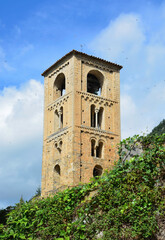 Fototapeta na wymiar BEGET, CATALONIA, SPAIN, EUROPE, SEPTEMBER 2020. Fantastic tower in the Romanesque church of San Cristóbal surrounded by greenery in the beautiful medieval town of Beget