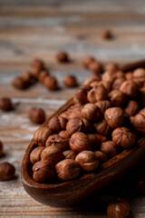 Full wooden rustic bowl of roasted hazelnuts on a wooden table, market catalogue photo