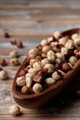 Full wooden rustic bowl of roasted hazelnuts on a wooden table, market catalogue photo