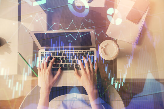 Double exposure of woman hands working on computer and forex chart hologram drawing. Top View. Financial analysis concept.