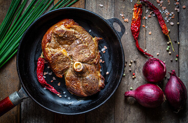lamb meat steak on pan on wooden table with vegetables