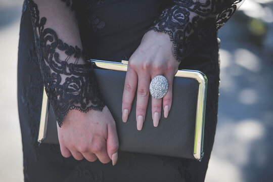 Closeup shot of a female in a fancy evening dress holding a clatch bag