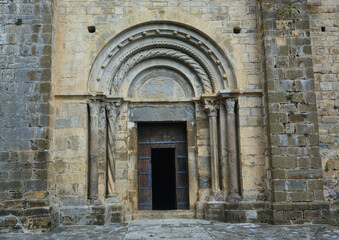 Fototapeta na wymiar BEGET, CATALONIA, SPAIN, EUROPE, SEPTEMBER 2020. Fantastic main door of the Romanesque church of San Cristóbal with columns on both sides and an upper arcade in the beautiful medieval town of Beget