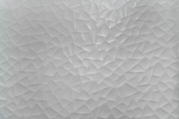 Background texture of a white ceramic wall with triangular goemetricals shapes.
