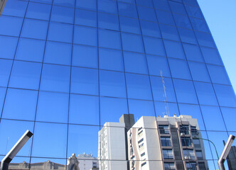 Fototapeta premium edifico con piel de vidrio reflejando la arquitectura alrededor en la ciudad de bahia blanca argentina