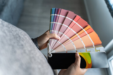 Close up on hands of unknown female person holding color palette at home in apartment - Woman...