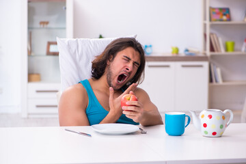 Young man waking up at home