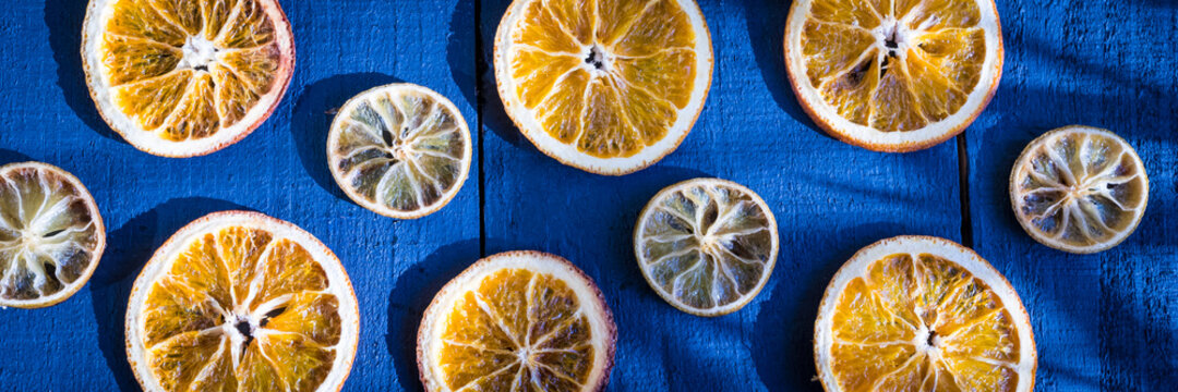 Conceito design laranja com lim&atilde;o desidratados sobre o tampo de madeira azulado