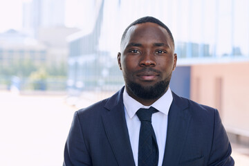 Fototapeta premium Young African businessman in elegant suit with tie standing in front of camera