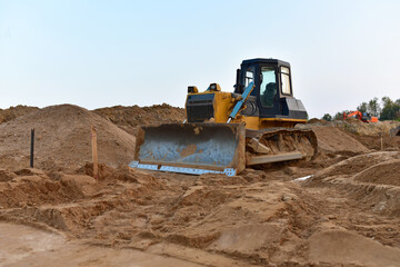 Dozer on earthmoving at construction site. Bulldozer on road work. Construction machinery and...