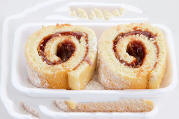 Rocambole. Rolled guava paste cake. Brazilian food. Rolled up cake with sweet filling, usually guava paste, on white background. Homemade dessert