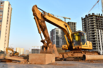 Excavator on earthmoving at construction site. Backhoe dig pit foundation.  Construction machinery...