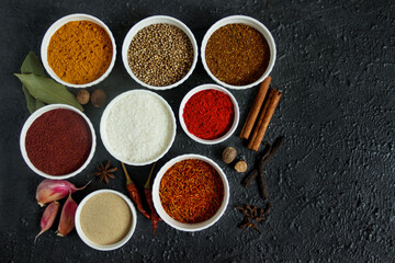 Spice on a black table - saffron, nutmeg, vanilla and star anise. Fragrant seasonings.