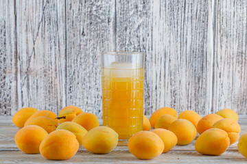 Fresh apricots with icy juice side view on a wooden background