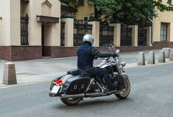 Obraz na płótnie Canvas Motorcyclist on a motorcycle moves along the street