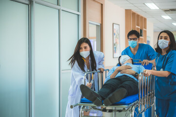 Hospital Emergency Doctor Team and Nurse Staff Carrying Stretcher with Patient from the Accident Ambulance Running to the Surgery Room © chokniti