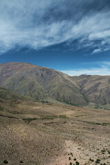 View of the popular landmark Bishop's slope in the Andes mountain range. The green field leading to the beautiful textured hills under a blue sky. 