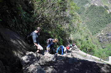 Hikers walking down the very steep steps of Huayna (Wayna) Picchu, the mountain behind Machu Picchu