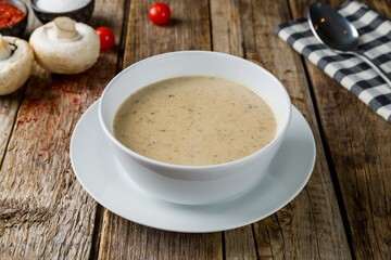Cream soup of mushrooms on old wooden table