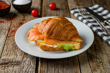 croissant with salmon on old wooden table