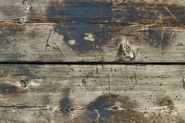 The background of two horizontal aged wooden boards. Surface with bitches, deformed by sharp...